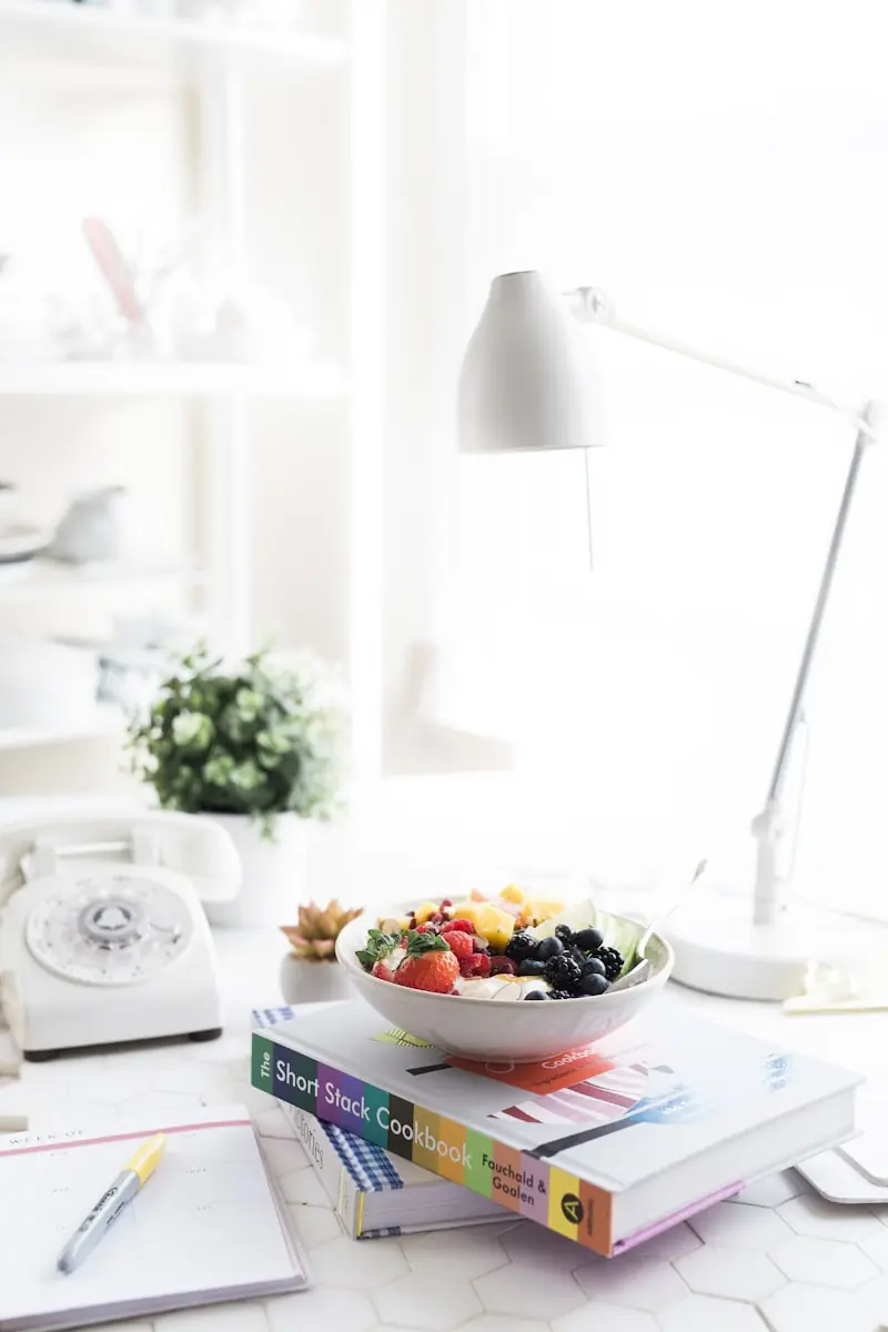 Cozinha branca e luminosa com uma taça de fruta