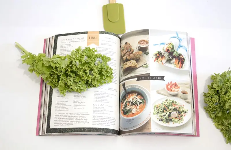 Livro de receitas aberto ao lado de alface fresca